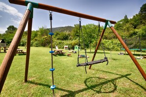 A playground with swings and a picnic table.
