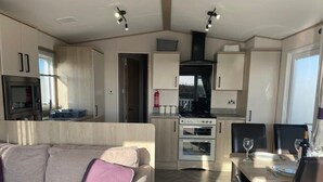 Un espacio habitable compacto con kitchenette, comedor y sofá.