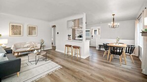 En moderne lejlighed med stue, spiseområde og køkken.