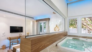 A modern bathroom with a bathtub, a wooden vanity, a mirror, and a television. - So White Beach Resort (Ayia Napa)