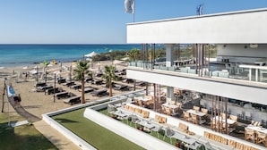 A modern hotel with a rooftop bar, outdoor seating, and a view of the beach and sea. - So White Beach Resort (Ayia Napa)