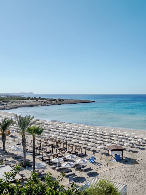 On the beach, white sand, sun-loungers, beach umbrellas
