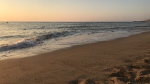 Une plage avec un ciel dégagé et une mer calme.