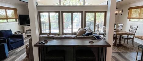 A spacious kitchen with a large island, wooden flooring, and a ceiling fan.