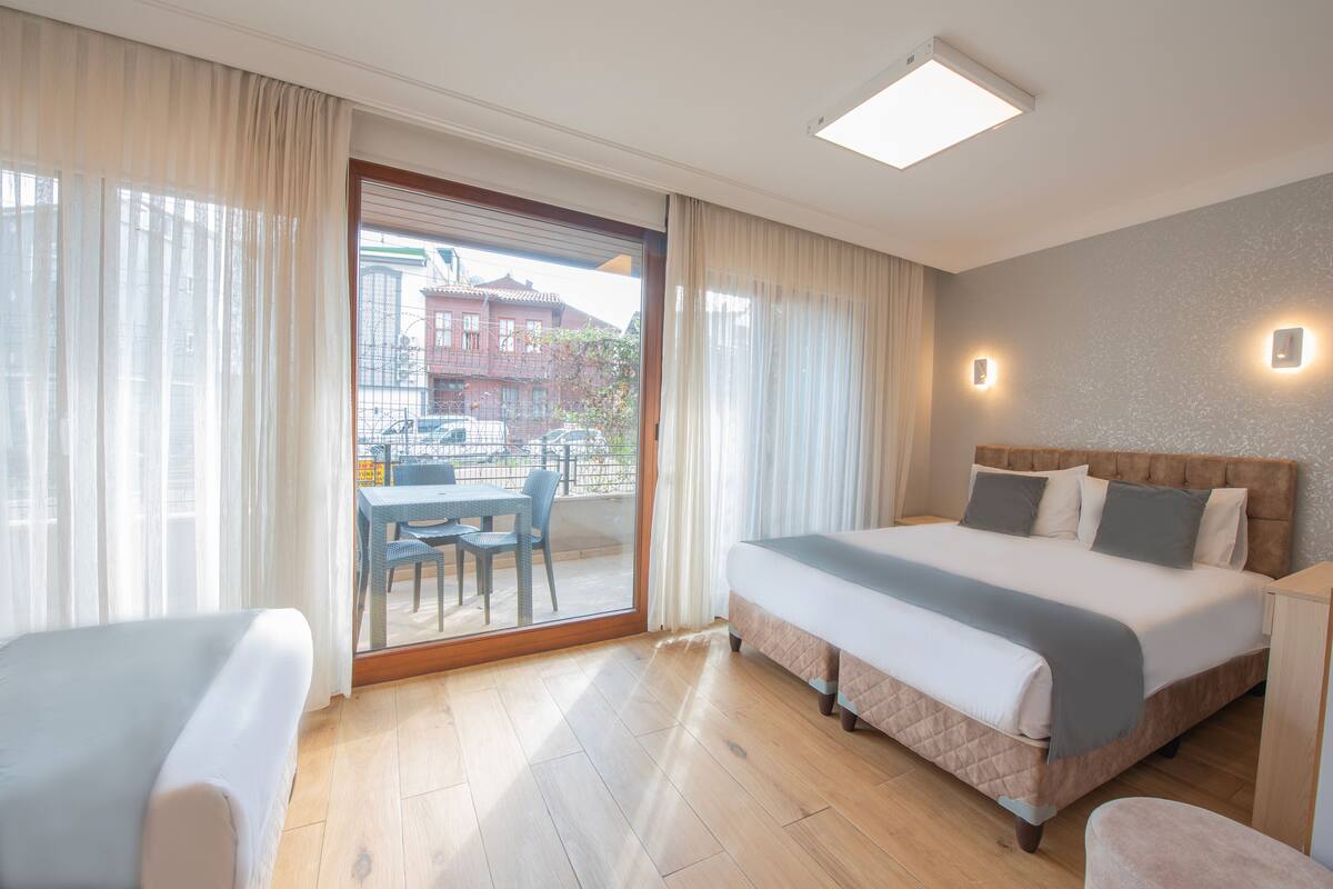 A hotel room with a large bed, a desk, and a view of the outside.