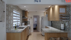 A modern kitchen with wooden cabinets, a built-in oven, and a sink.