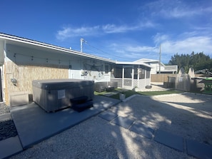 A residential property with a hot tub, outdoor seating, and a covered patio area.