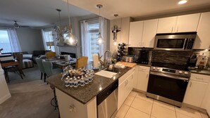 A modern kitchen with granite countertops, stainless steel appliances, and a central island.
