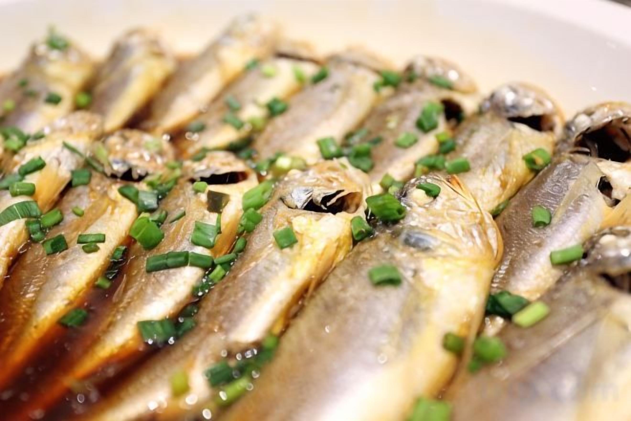 A close-up of a dish with fish garnished with chopped green onions.