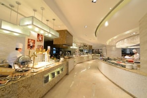 Cozinha moderna com eletrodomésticos de aço inoxidável e bancada curva.
