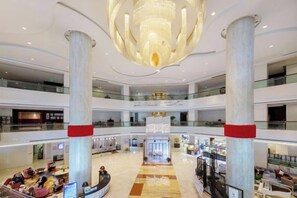 A multi-level atrium with a central column, a chandelier, and a seating area. - Haizhongzhou International Hotel Apartment Building (Zhoushan)