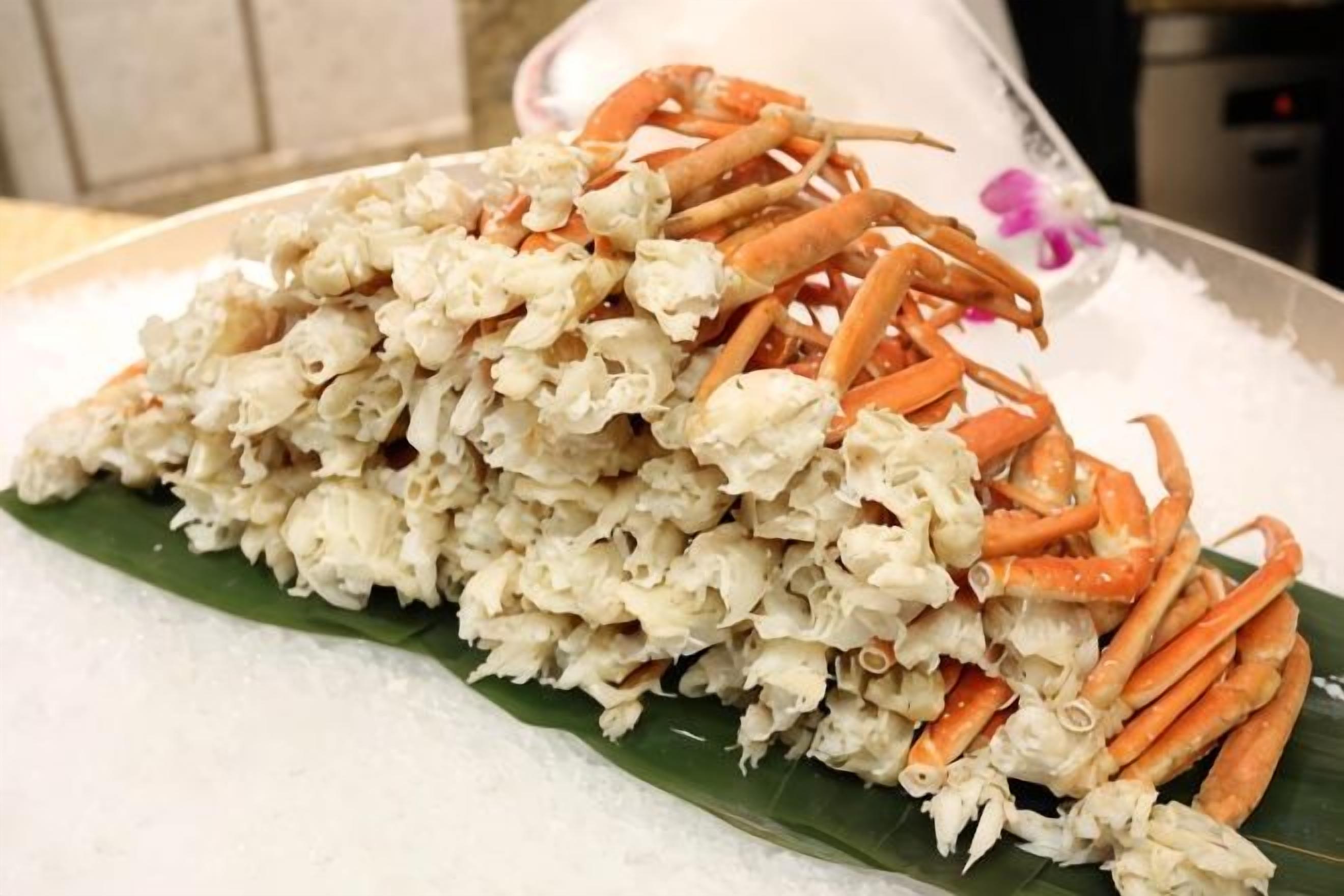 A pile of crab legs on a banana leaf.