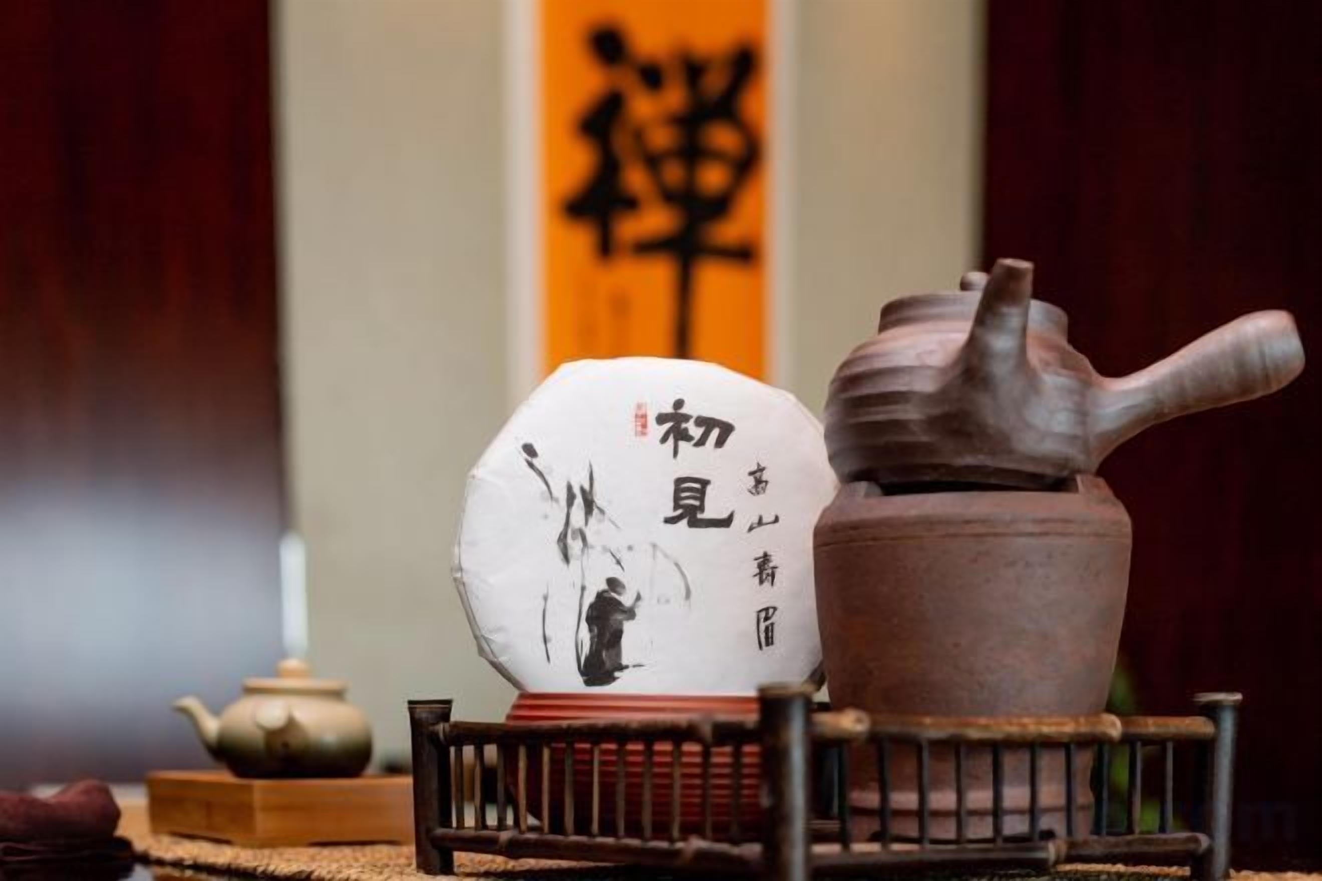 A traditional tea set with a teapot and a decorative ceramic piece with calligraphy.