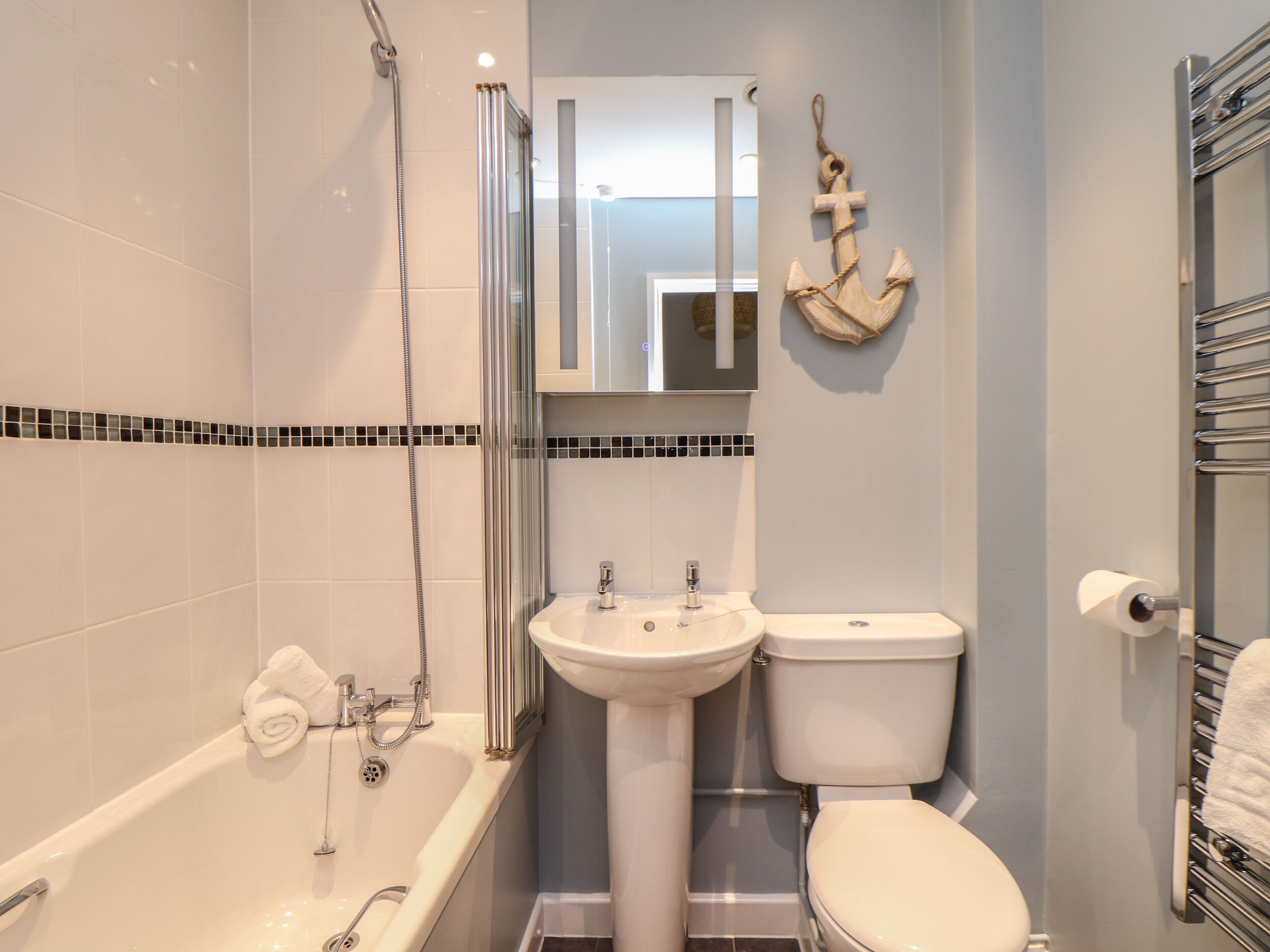 Une salle de bain avec une baignoire, un lavabo, des toilettes et un miroir.