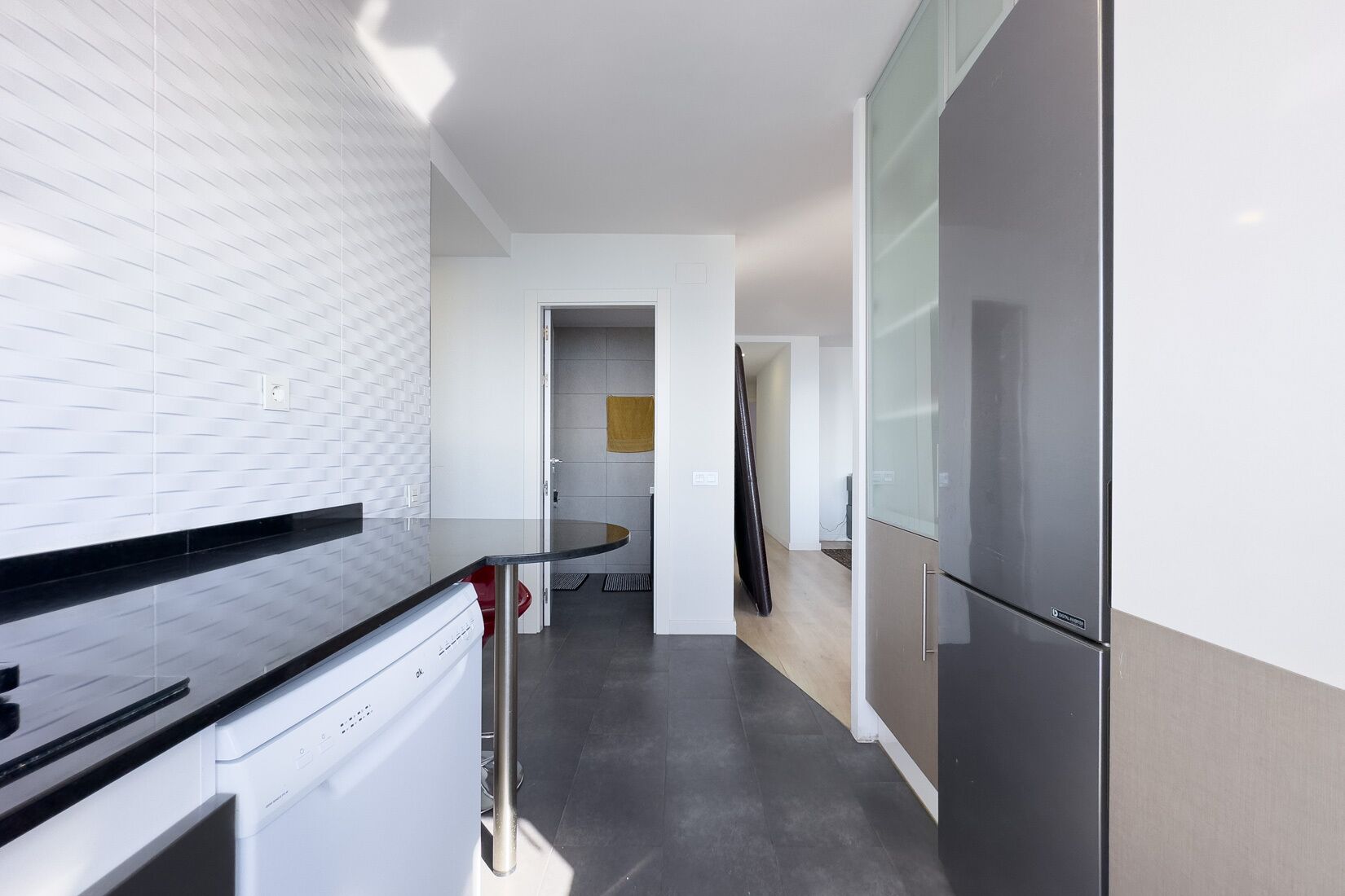 Una cocina moderna con lavavajillas, refrigerador y encimera.