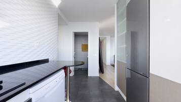 Una cocina moderna con lavavajillas, refrigerador y encimera.