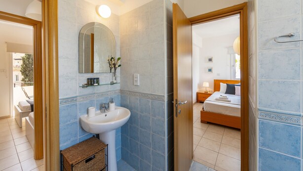 Ein Badezimmer mit Waschbecken, Spiegel und Fliesen.