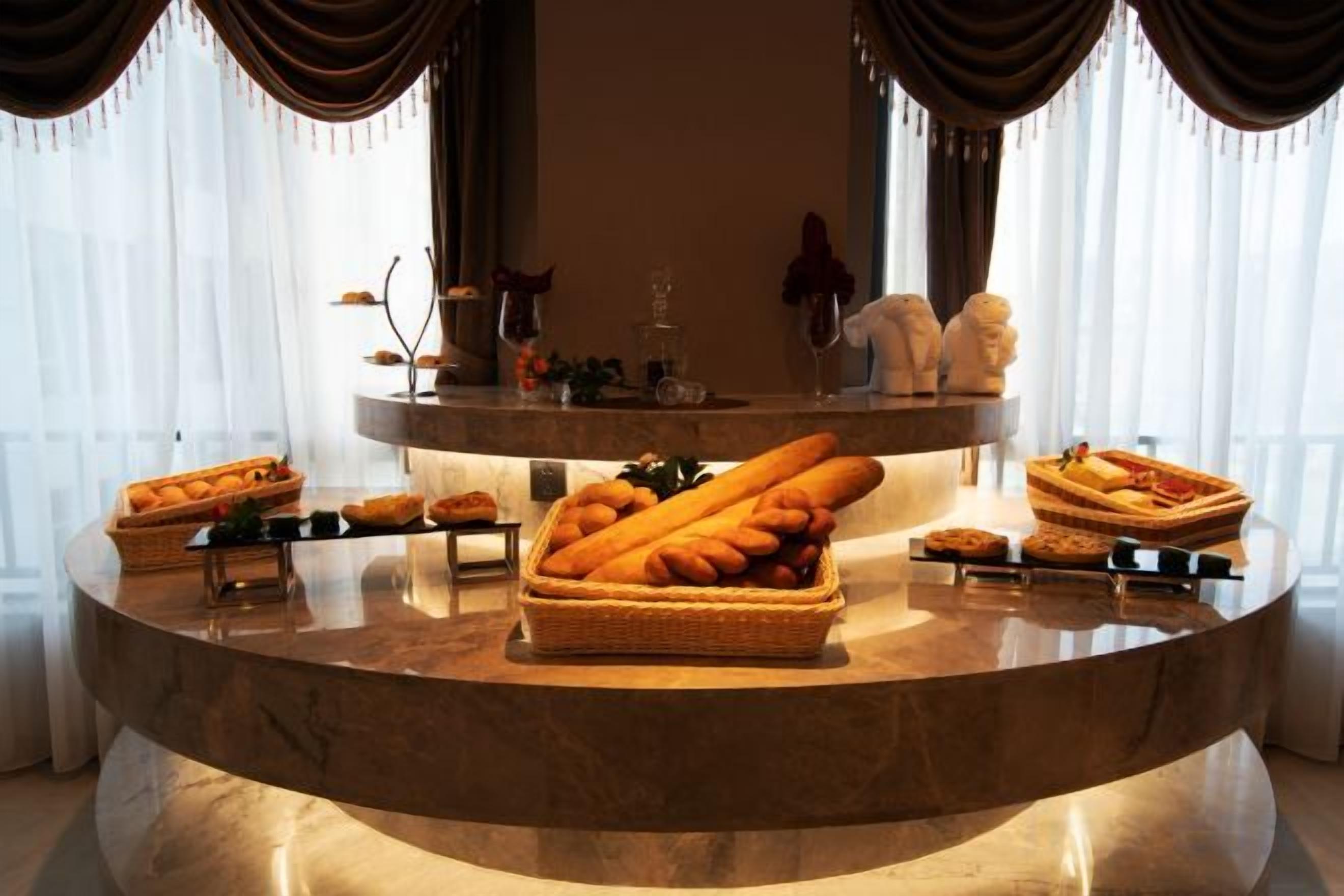 A marble counter with bread baskets and a tray of sandwiches.