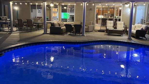 Zona de piscina con jacuzzi, mobiliario exterior y vista a la cocina.