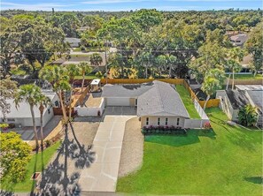 Set amidst a serene natural environment, this single-story house offers a peaceful retreat with a well-maintained lawn and mature trees.
