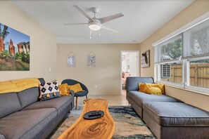Ein Wohnzimmer mit zwei Sofas, einem Couchtisch und einem Deckenventilator.