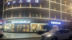 A hotel with a modern facade, illuminated signage, and a visible entrance. - Ruipo Hotel (Xiantao)