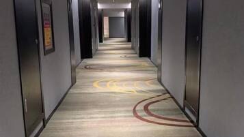 Un pasillo de hotel con piso alfombrado y puertas a ambos lados.