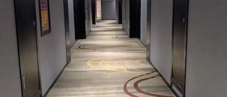 Un pasillo de hotel con piso alfombrado y puertas a ambos lados.