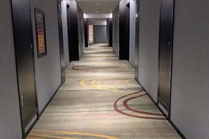 Un pasillo de hotel con piso alfombrado y puertas a ambos lados.