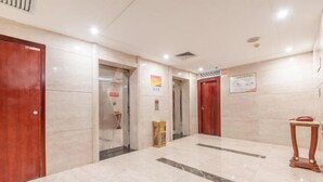 A hotel lobby with marble flooring, wooden doors, and a small wooden table. - Ruipo Hotel (Xiantao)