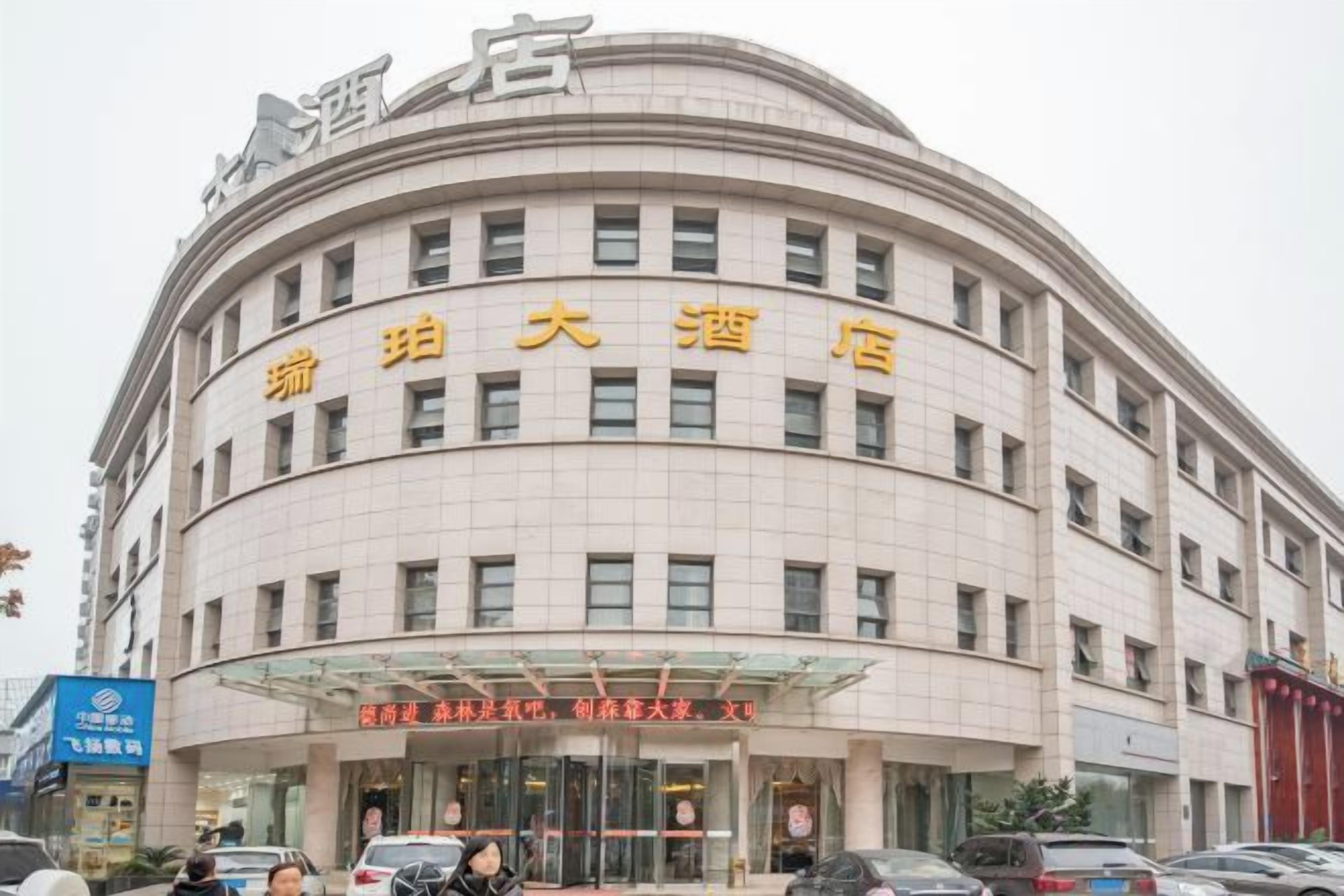 Un hotel con fachada curva, grandes ventanales y una entrada destacada con marquesina de vidrio.
