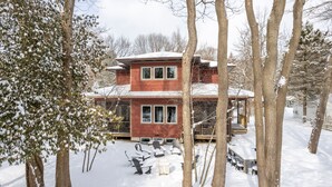 A two-story house with a deck and outdoor seating area.