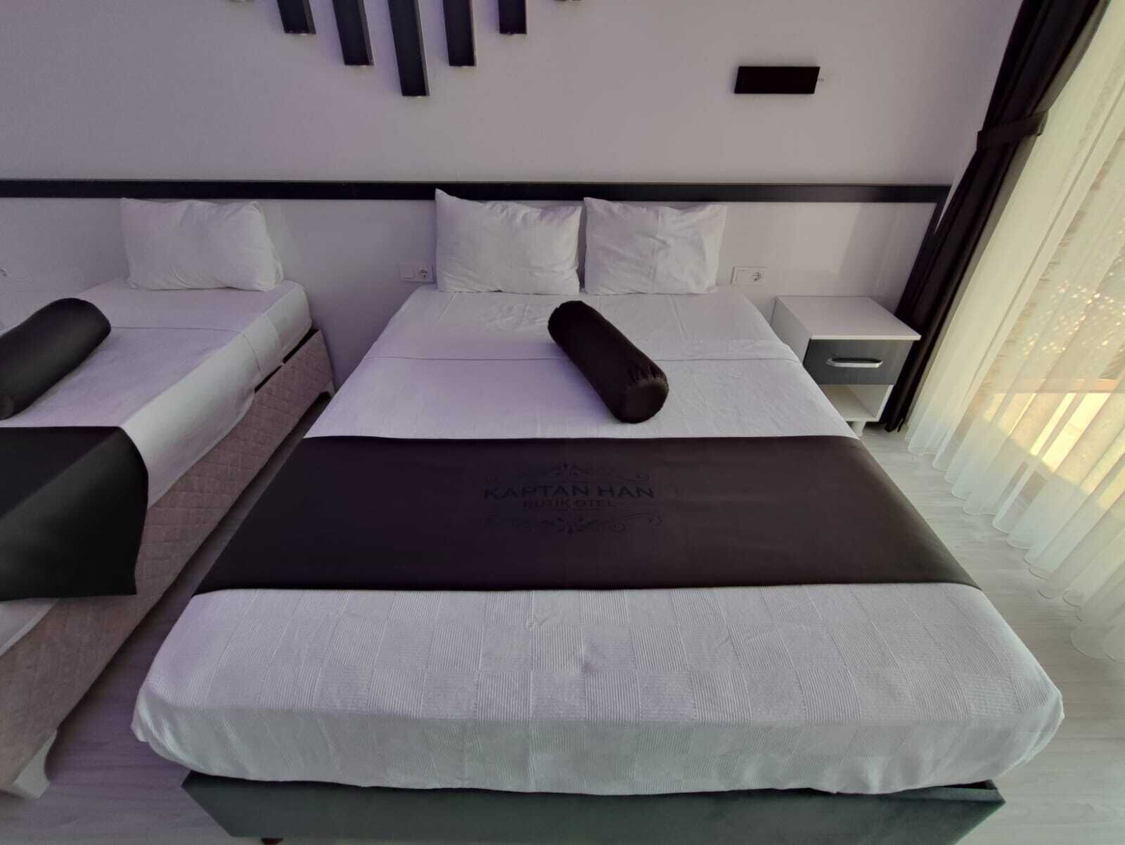 A modern hotel room with a large bed, two bedside tables, and a nightstand.
