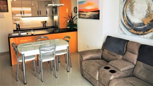 A modern kitchen with a dining area, a sofa, and artwork on the walls. - Comfortable, quiet apartment close to everything (Costa Adeje)