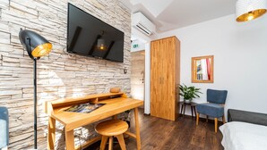 Una sala moderna con pared de piedra, un escritorio de madera y un televisor de pantalla plana.