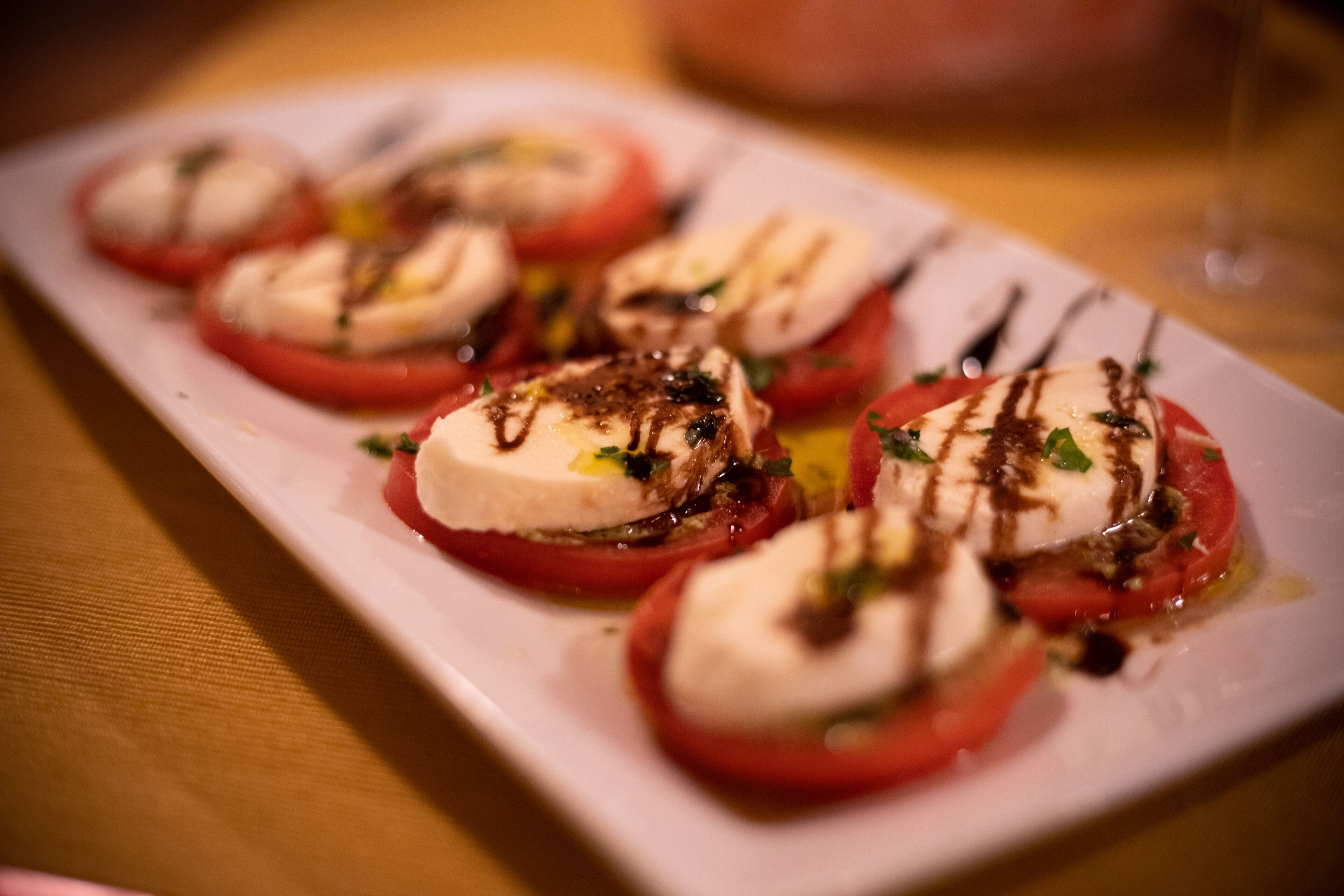 Uma travessa de aperitivos de tomate e mussarela.