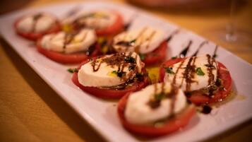 Uma travessa de aperitivos de tomate e mussarela.