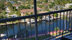 Ein Balkon mit Blick auf einen Fluss, Boote und eine Stadtlandschaft.