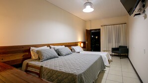 A bedroom with a large bed, a wooden bench, a desk, and a chair. - QUATRO ESTAÇOES PESQ. E HOTEL FAZENDA (Esmeraldas)