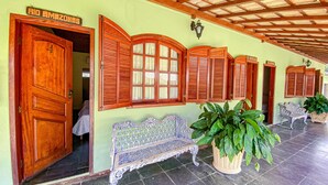 A traditional building with wooden doors and shutters, a bench, and potted plants. - QUATRO ESTAÇOES PESQ. E HOTEL FAZENDA (Esmeraldas)