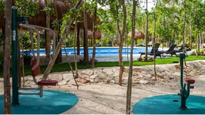 Area fitness esterna con piscina, attrezzature per esercizi e sdraio.