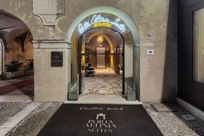 The entrance to Porta Altina Suites with a checkered floor and a neon sign above. - Porta  Altinia (Treviso)