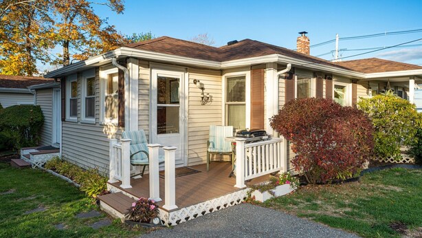 A single-story house with a front porch, a chimney, and a small garden area. - Charming Cottage Steps from Hulls Cove Beach & Entrance to Acadia! (Bar Harbor)