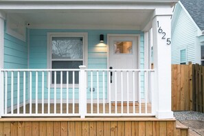 A house with a porch, a white door, and a mailbox.