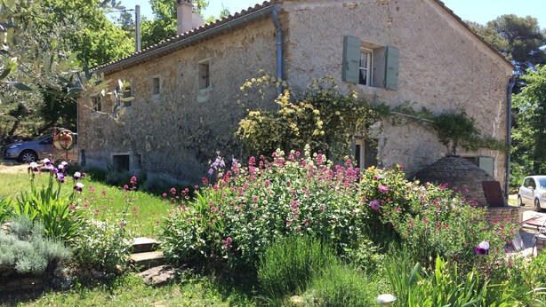 Un edificio de piedra rústica con jardín delantero.