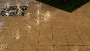 Un patio exterior con una fogata, sillas y luces colgantes.