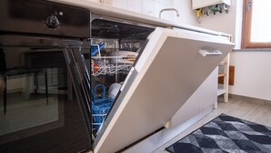 A kitchen with a dishwasher, oven, and tiled backsplash.