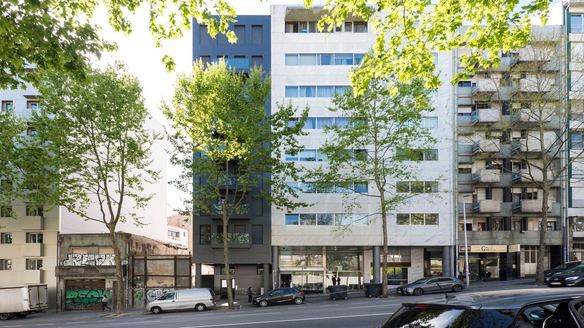 Ein mehrstöckiges Wohngebäude im modernen Architekturstil, mit Balkonen und großen Fenstern.