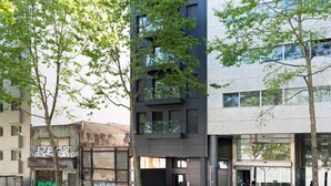 Un edificio moderno con diversi piani, ampie finestre e una facciata in vetro e metallo.
