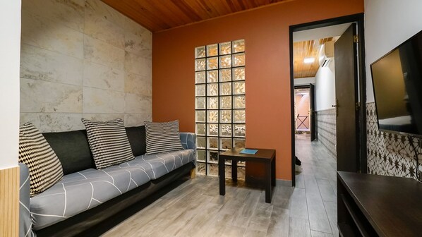 A living room with a sofa, a small table, and a TV.